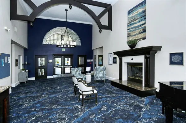 a living room with furniture a fireplace and a chandelier