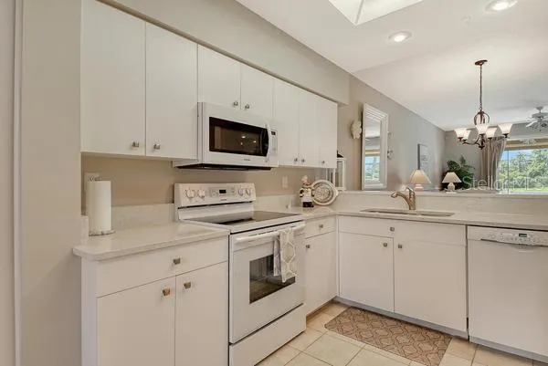 a kitchen with white cabinets and white appliances