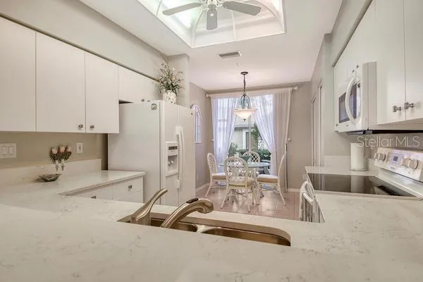 a kitchen with stainless steel appliances granite countertop a sink refrigerator and cabinets