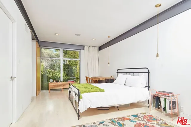 a bedroom with a bed and a large window