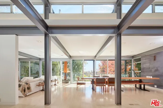 a living room with furniture and floor to ceiling windows