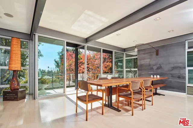 a dining room with furniture and a floor to ceiling window
