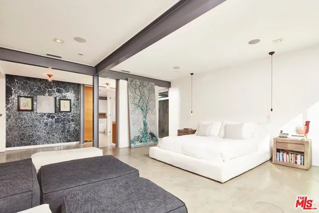 a bedroom with a large bed and a chandelier