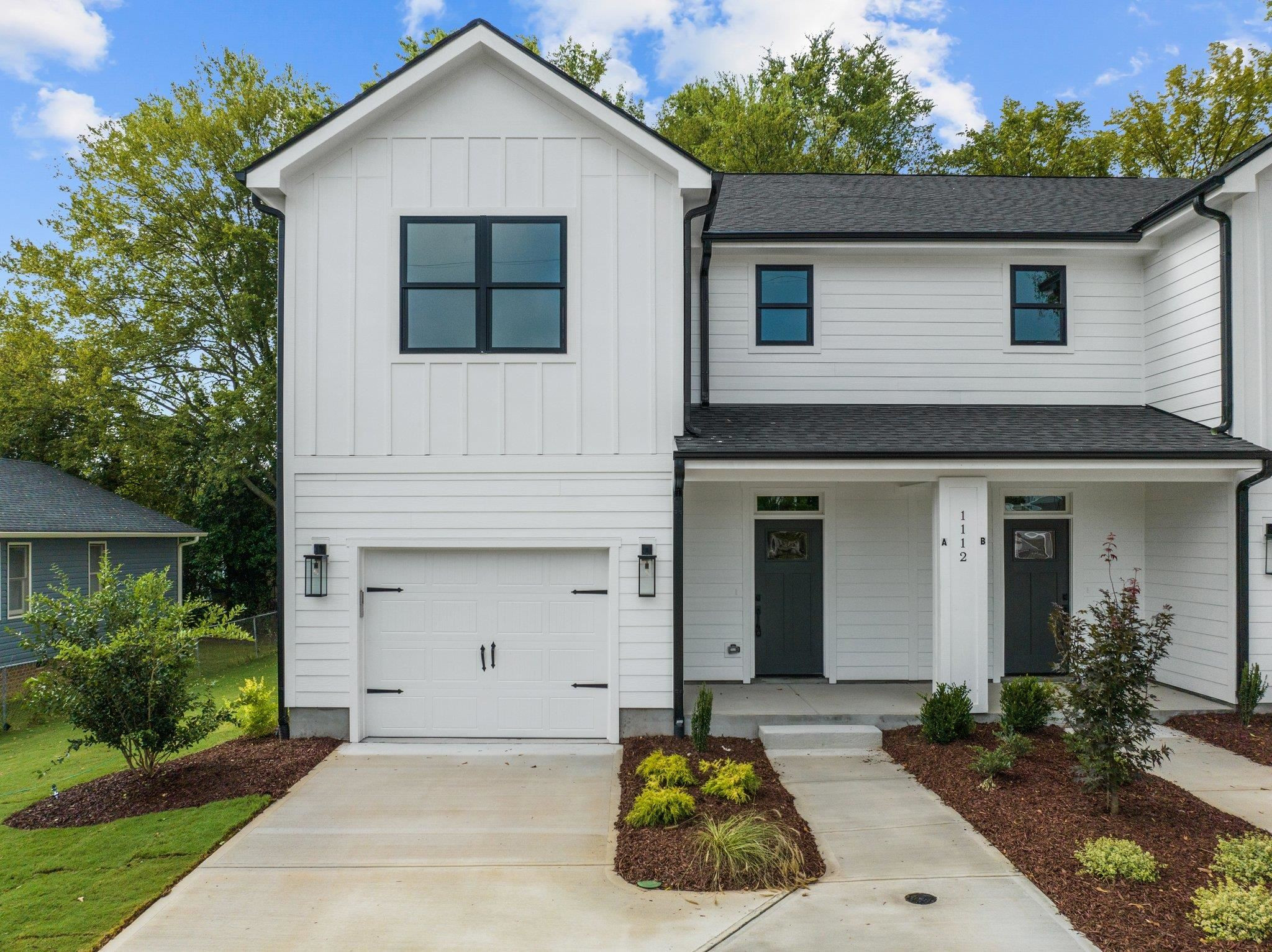 a front view of a house with a garden and garage