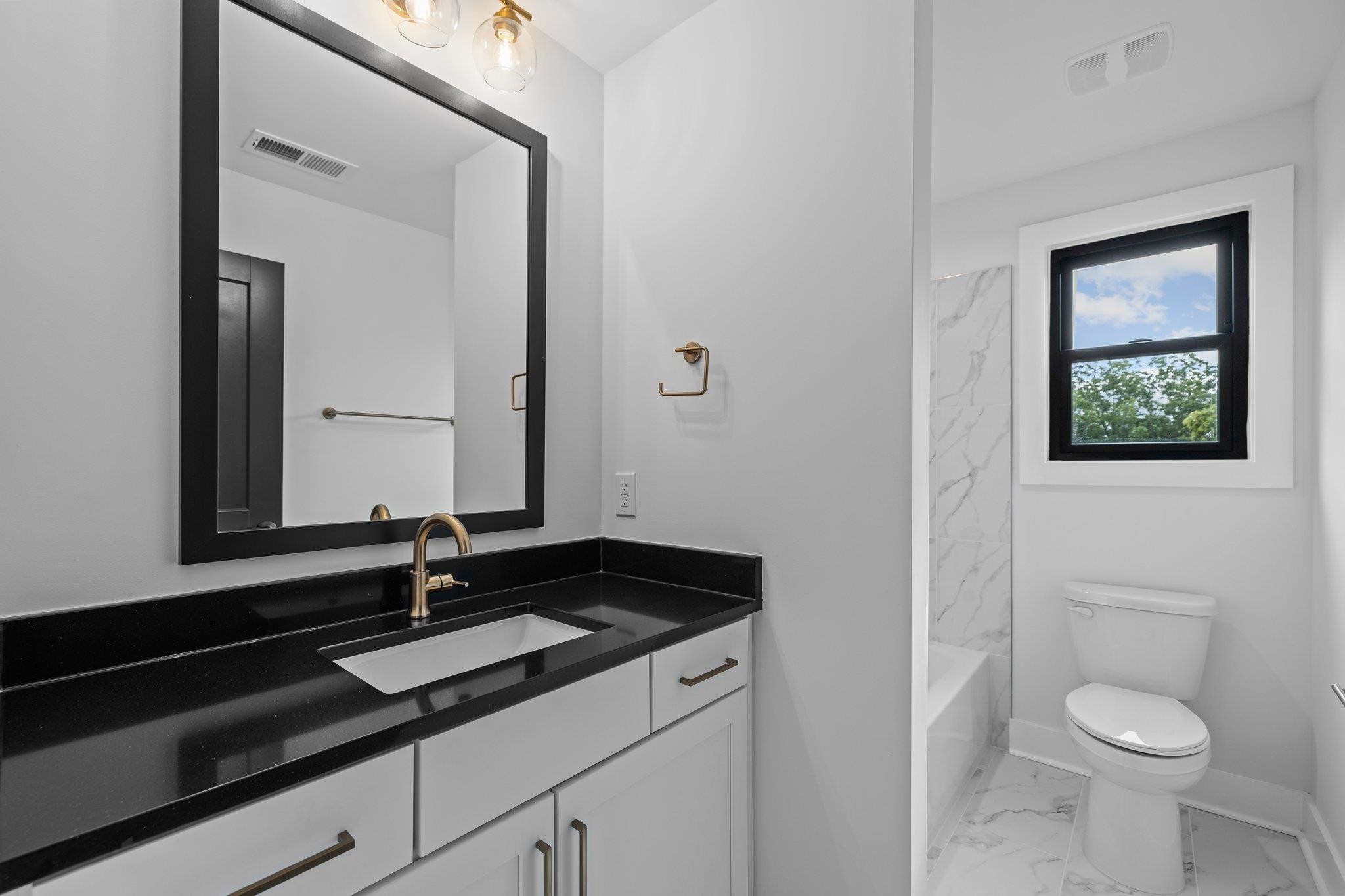 1112 Pender Street Raleigh, NC 27610 - Photo 26 of 56 a bathroom with a granite countertop sink and a toilet