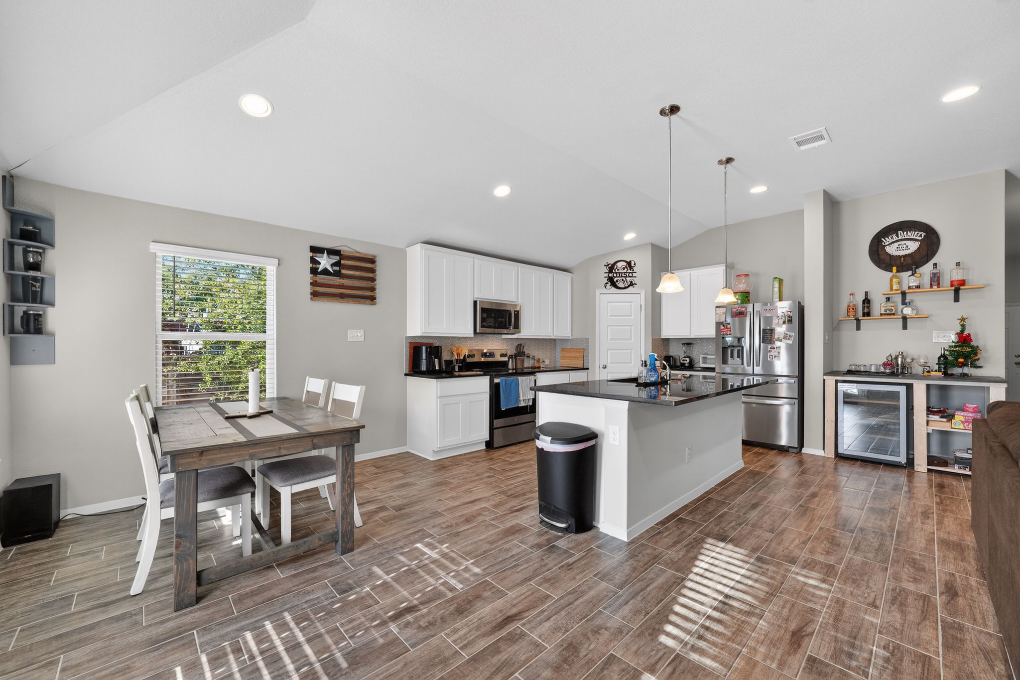 20703 Ridgeview Road Lago Vista, TX 78645 - Photo 16 of 30 a kitchen with stainless steel appliances granite countertop a refrigerator a stove top oven a sink dishwasher a dining table and chairs with wooden floor