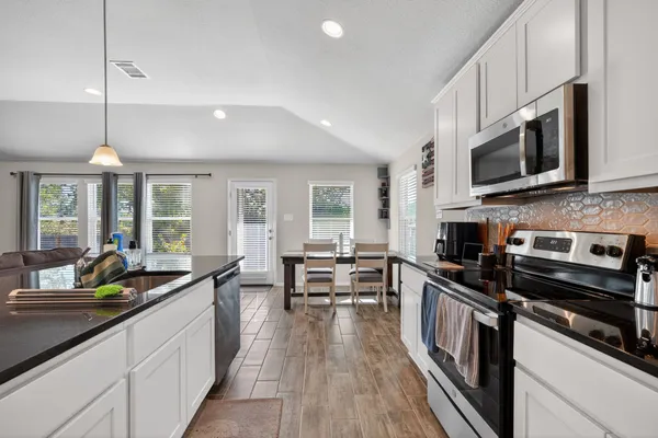 a kitchen with stainless steel appliances granite countertop a sink refrigerator and microwave
