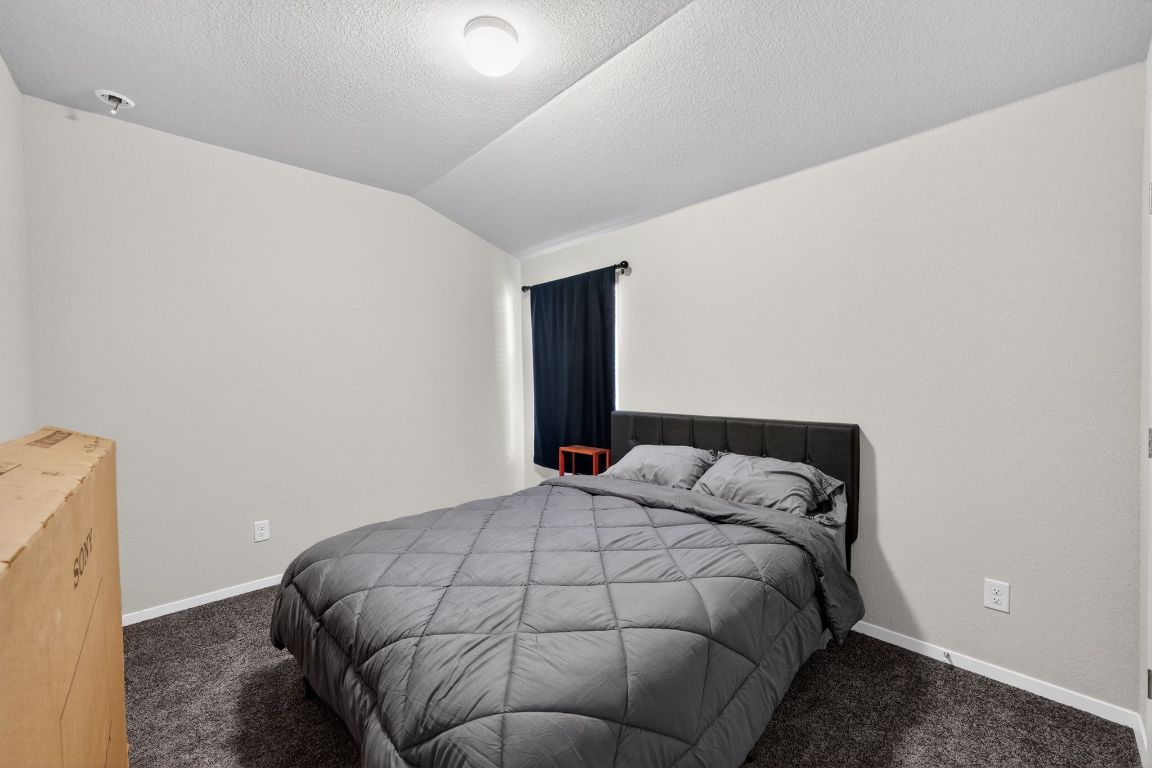 20703 Ridgeview Road Lago Vista, TX 78645 - Photo 20 of 30 a bedroom with a bed and chair