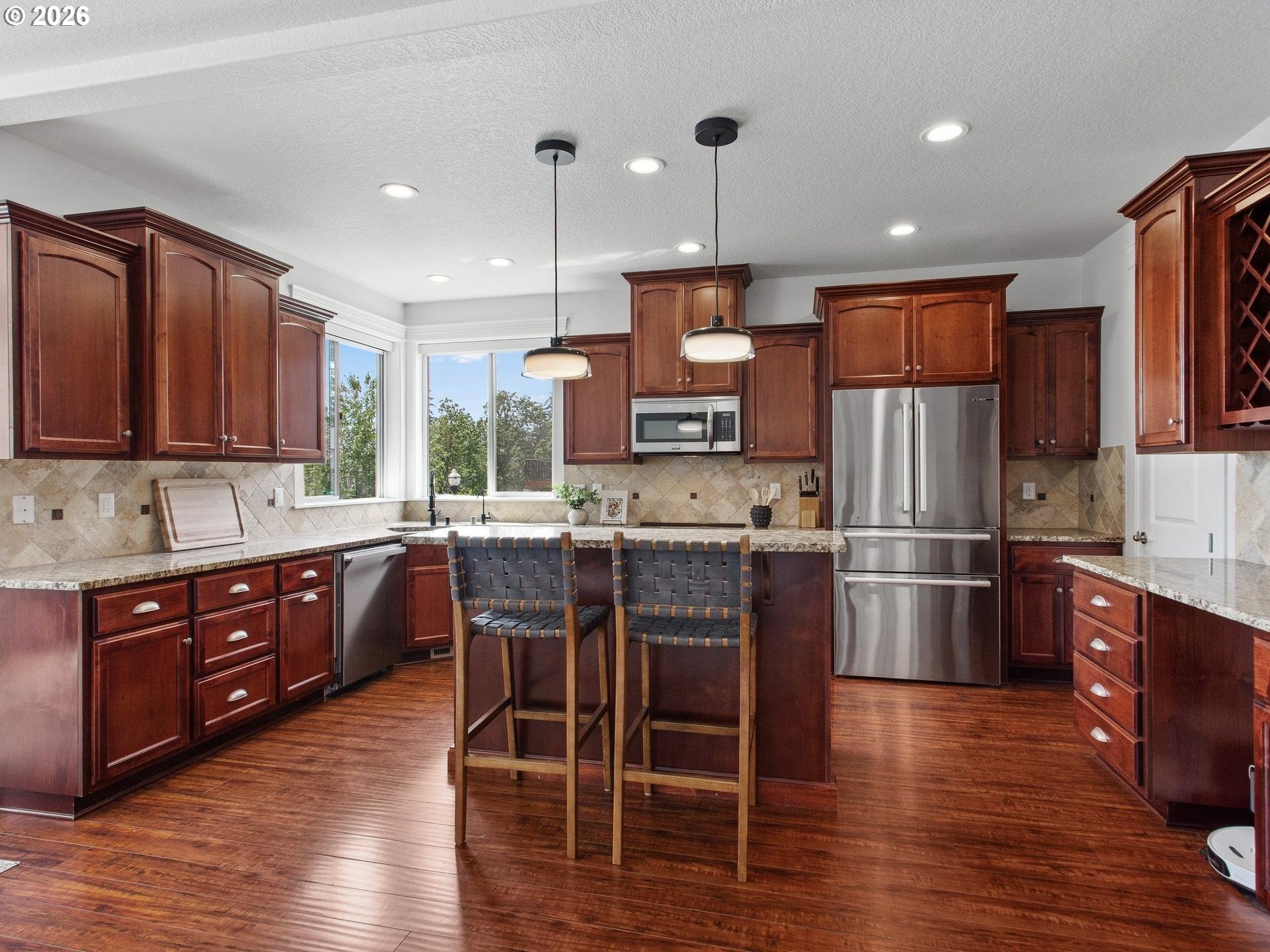 1012 Northwest Goodwin Street Camas, WA 98607 - Photo 7 of 44 a kitchen with stainless steel appliances wooden floors wooden cabinets and a refrigerator