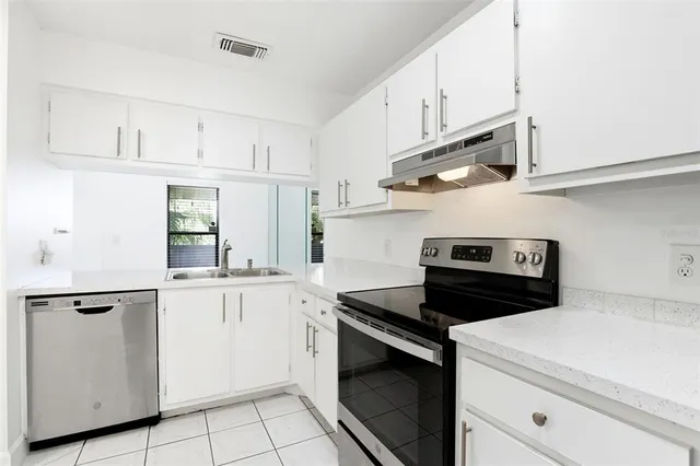a kitchen with white cabinets and white appliances
