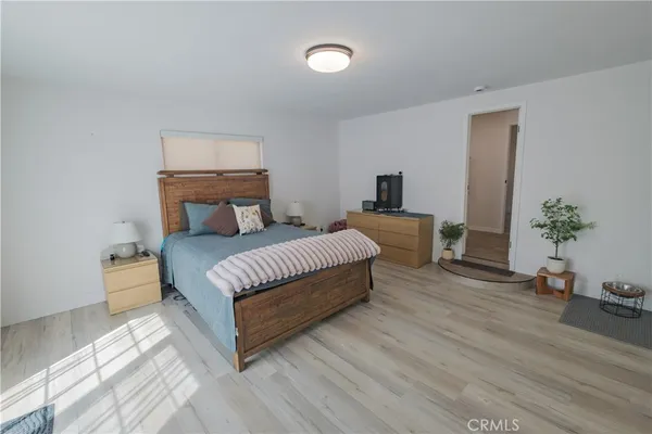 a spacious bedroom with a bed and a potted plant on table