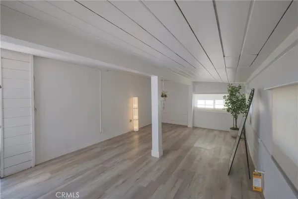 a view of a room with wooden floor and potted plant