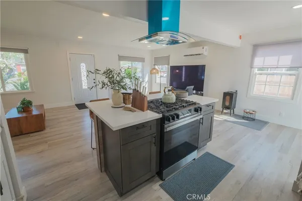a kitchen with stainless steel appliances granite countertop a stove and a wooden floors