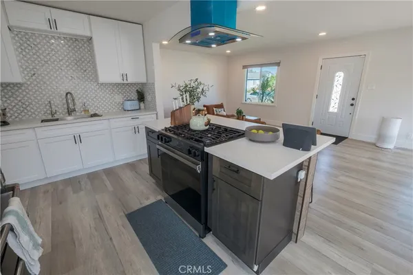 a kitchen with a stove cabinets and wooden floor