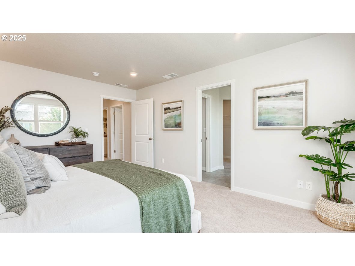 2150 36th Avenue Forest Grove, OR 97116 - Photo 20 of 24 a bedroom with a bed a mirror and a potted plant