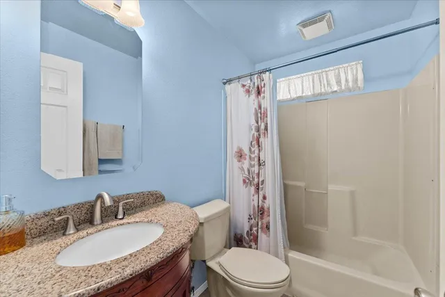 a patio with table and chairs and potted plants
