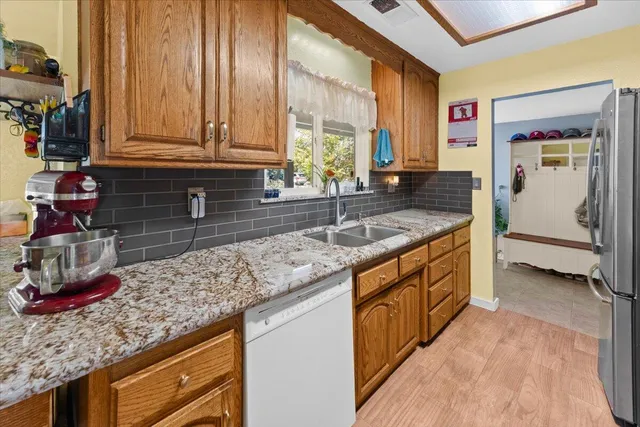 a kitchen with stainless steel appliances granite countertop a sink and a wooden cabinets