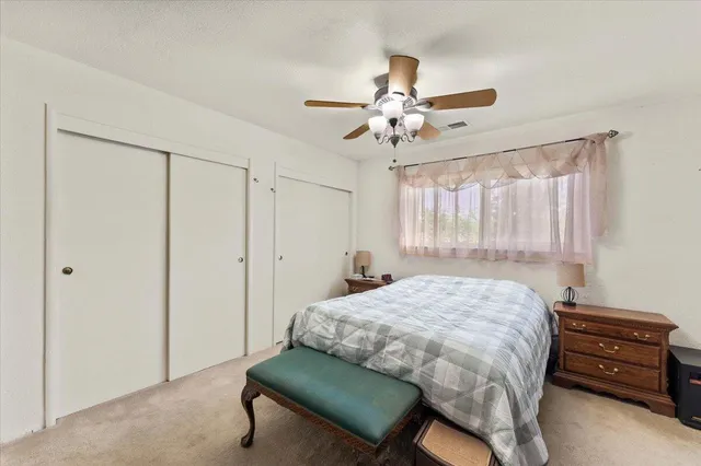 a bedroom with a bed a flat screen tv and a chandelier