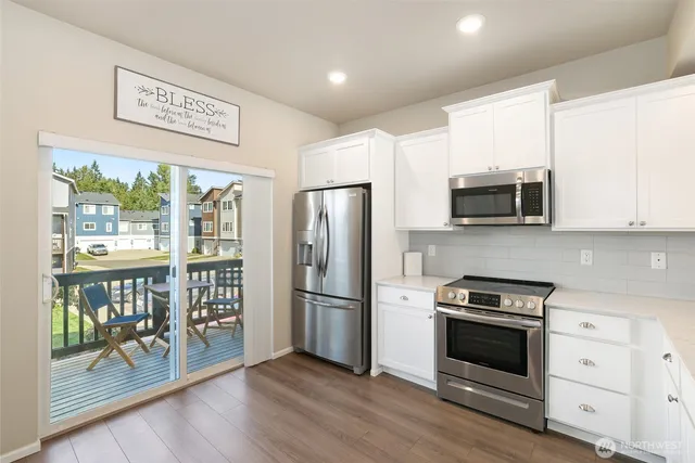 a kitchen with stainless steel appliances granite countertop a refrigerator microwave and stove top oven