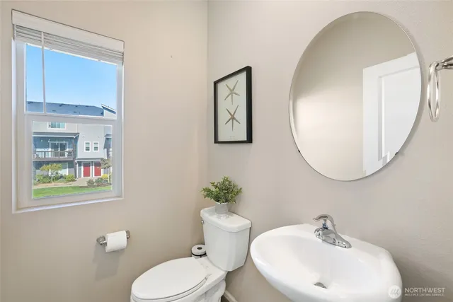 a bathroom with a toilet a sink and mirror