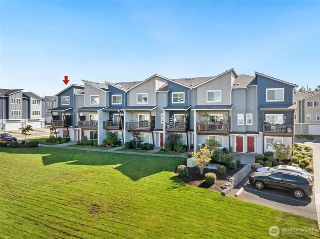a front view of a house with a garden and lake view
