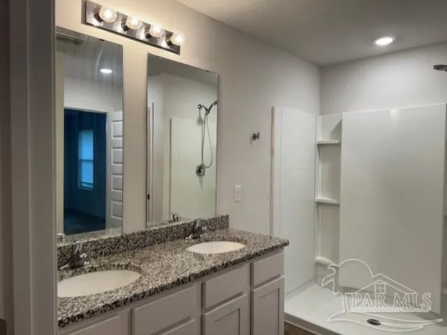a bathroom with a granite countertop sink and a mirror