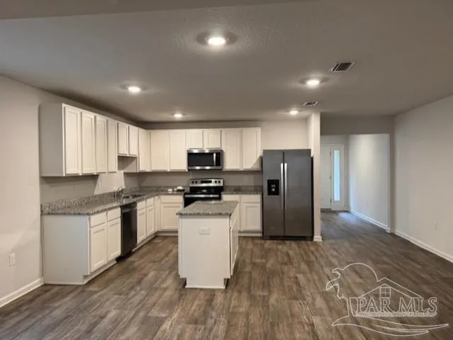 a kitchen with stainless steel appliances granite countertop a refrigerator stove top oven and sink