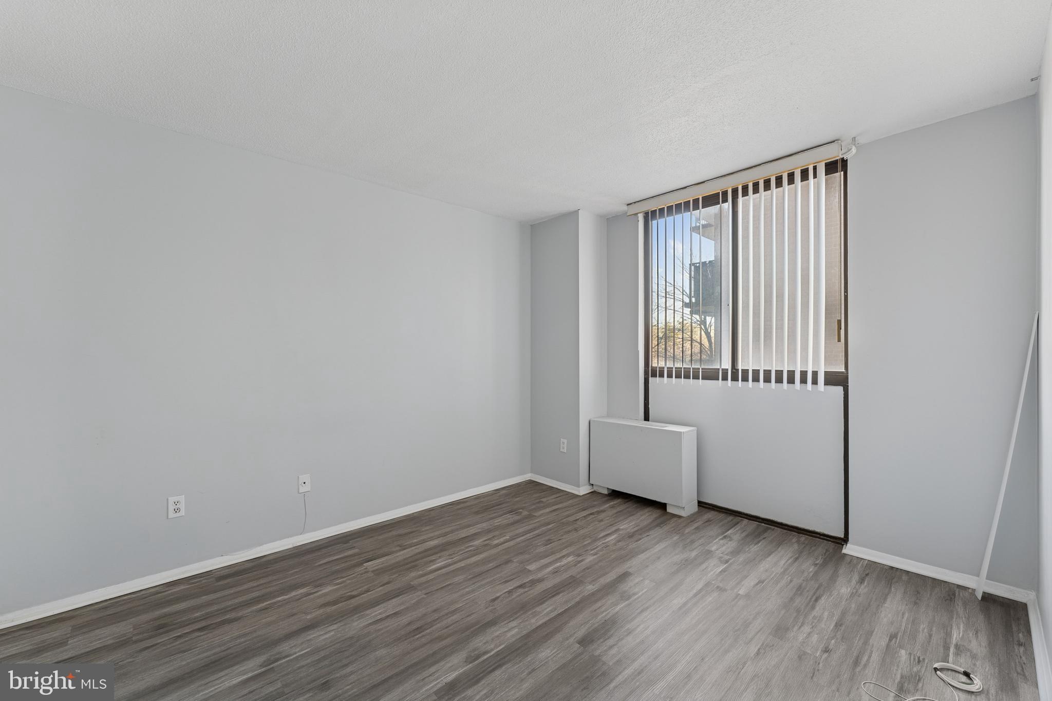 6100 Westchester Park Drive, Unit 520 College Park, MD 20740 - Photo 9 of 15 an empty room with wooden floor and windows