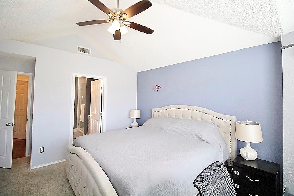 314 Pool Street Cedar Hill, TX 75104 - Photo 12 of 25 a bedroom with a bed and a chandelier