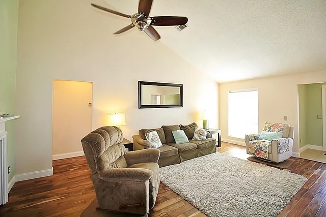 a living room with furniture and a wooden floor
