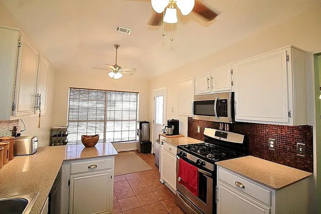a kitchen with stainless steel appliances granite countertop a stove and a sink