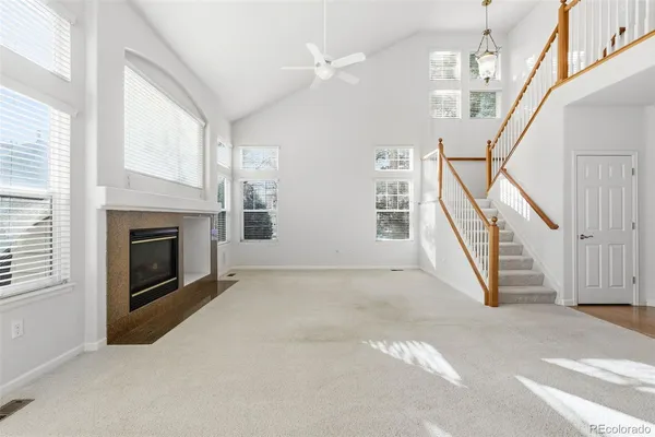 a view of an empty room with fireplace and stairs