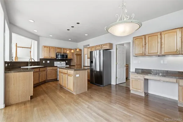a large kitchen with cabinets wooden floor and stainless steel appliances