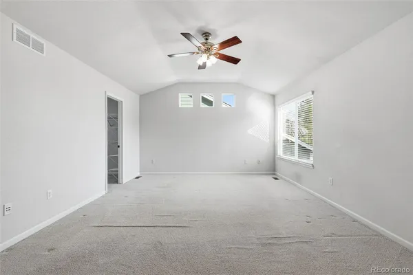 an empty room with a window and a ceiling fan