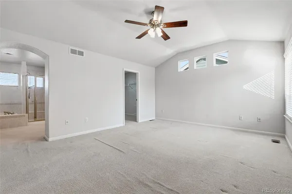 en empty room with ceiling fan and window