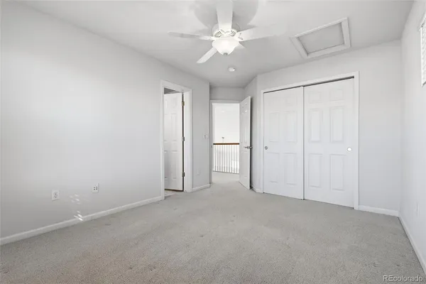 an empty room with a ceiling fan and a window
