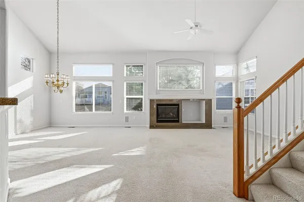 a view of an empty room with fireplace and a window