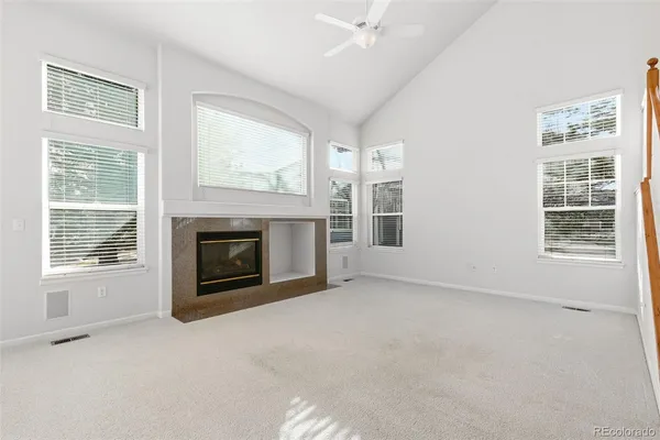 an empty room with windows and fireplace