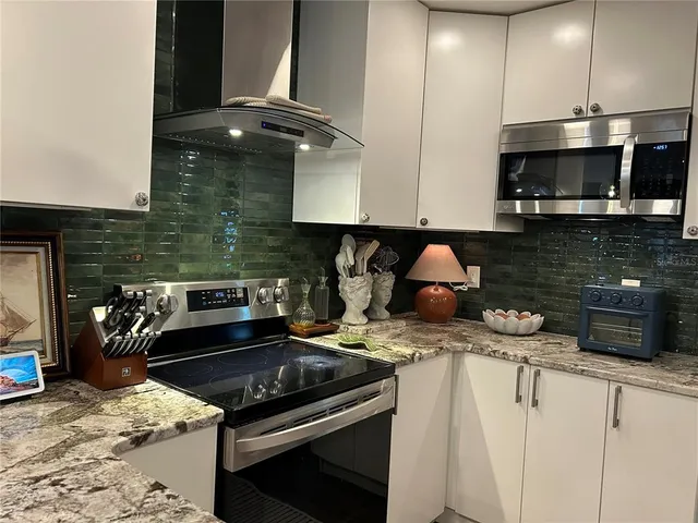 a kitchen with stainless steel appliances granite countertop a stove and a microwave