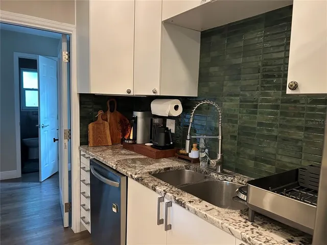 a bathroom with a granite countertop sink a mirror and shower