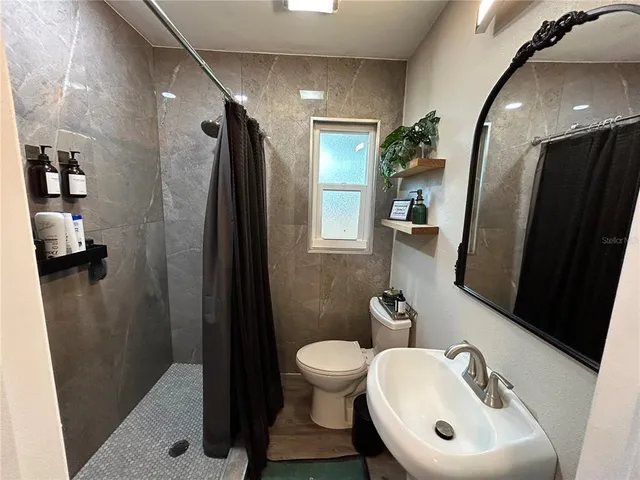 a bathroom with a sink toilet and shower