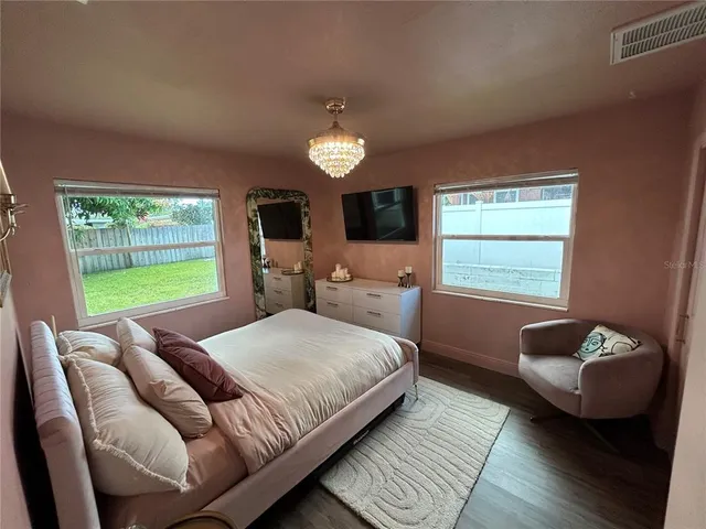 a bedroom with a bed couches chair and a large window