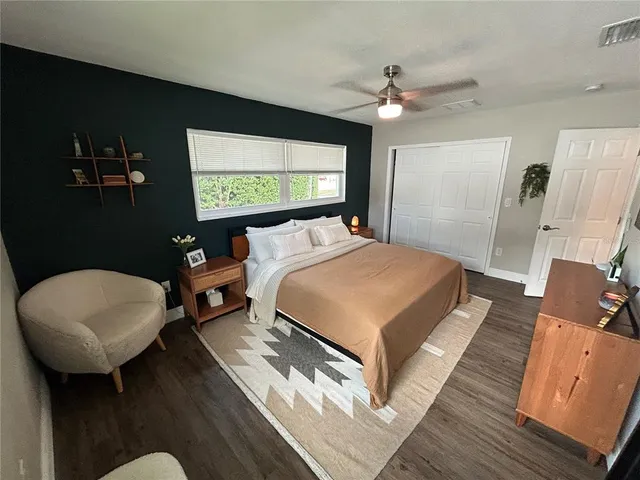 a spacious bedroom with a bed a couch and a flat screen tv