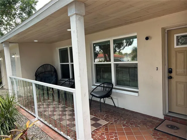 a view of a balcony with wooden floor and a potted plant