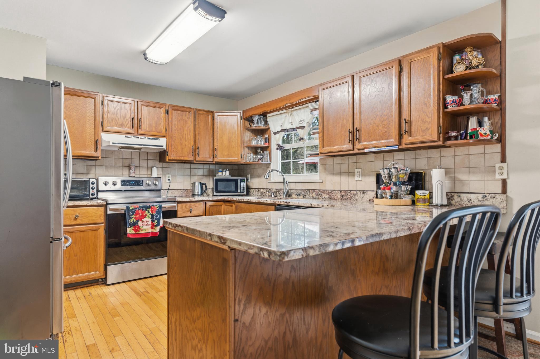 12574 Bristow Road Nokesville, VA 20181 - Photo 15 of 38 a kitchen with stainless steel appliances granite countertop a sink a stove and a refrigerator