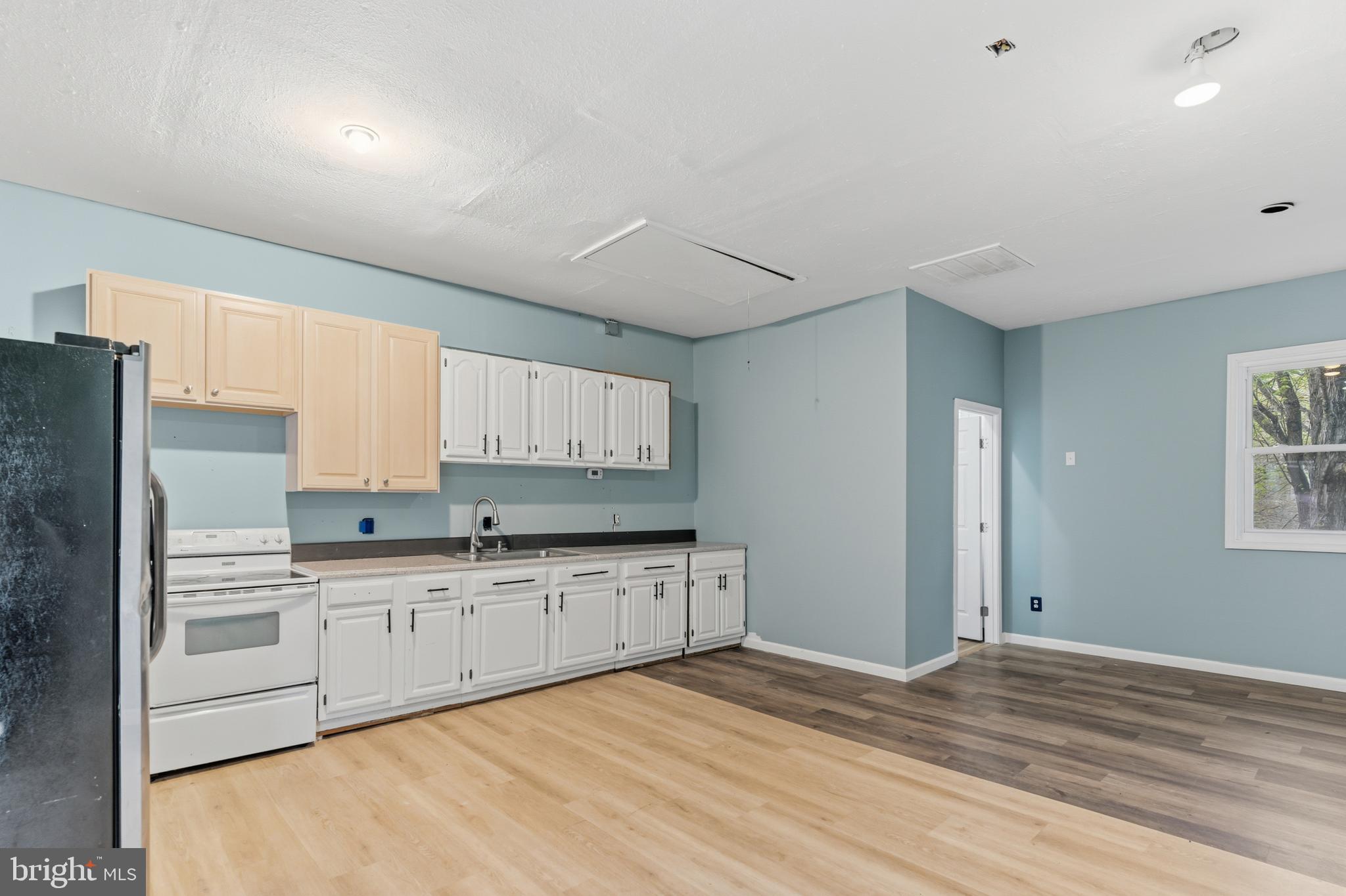 12574 Bristow Road Nokesville, VA 20181 - Photo 31 of 38 a kitchen with stainless steel appliances granite countertop a stove a sink and white cabinets