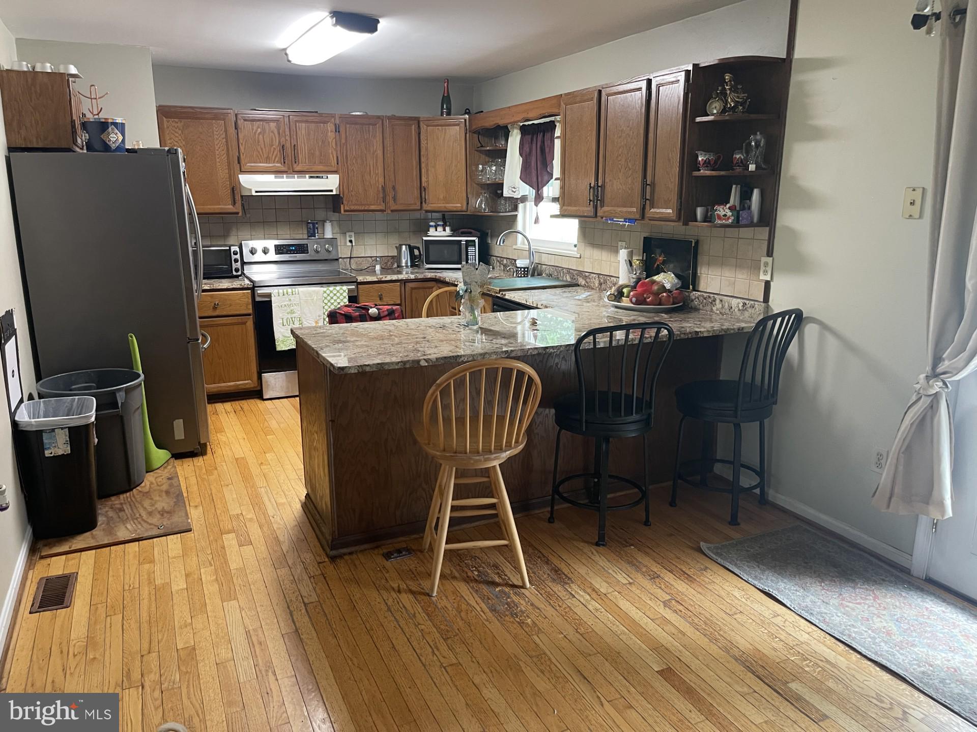 12574 Bristow Road Nokesville, VA 20181 - Photo 10 of 38 a kitchen with stainless steel appliances granite countertop a table chairs sink and cabinets