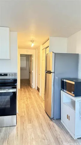 a kitchen with a refrigerator and a stove top oven