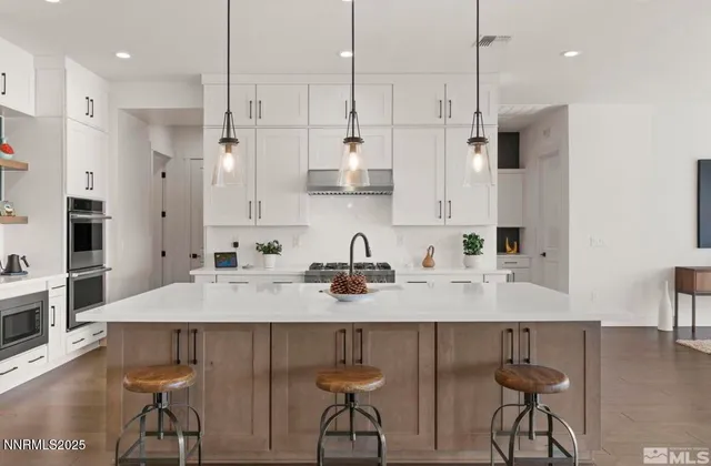 a large kitchen with kitchen island a sink appliances and cabinets