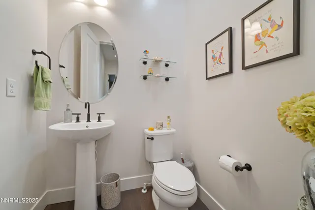a view of a livingroom with wooden floor and bathroom
